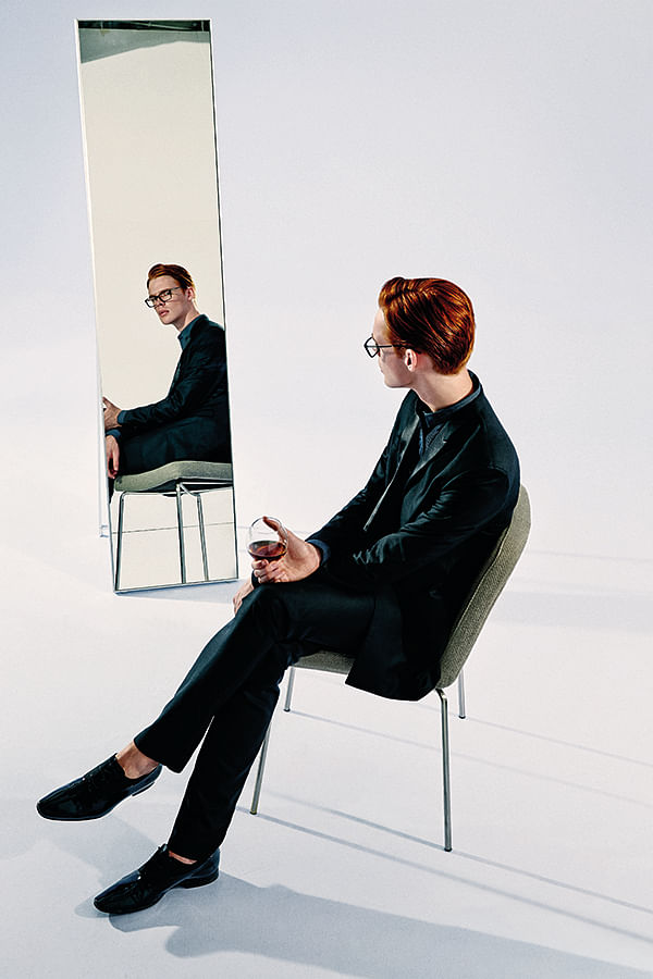 Dress down a tuxedo for a stylish take on smart-casual. Black wool tuxedo suit, black cotton shirt and black patent leather shoes, from Dior Home. Glasses from Burberry.