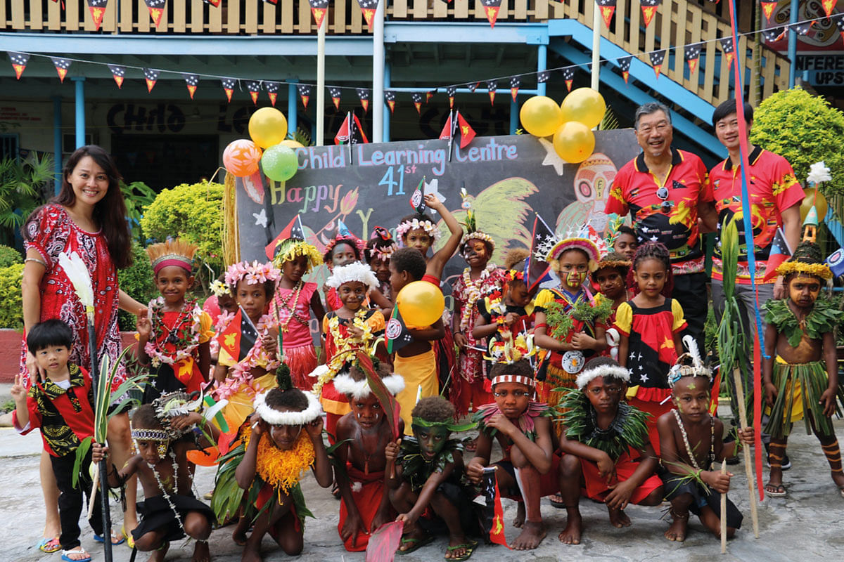 Wendi Chan and Derrick Seeto, founders and co-CEOs of Parlour Group with School Children in Papua New Guinea