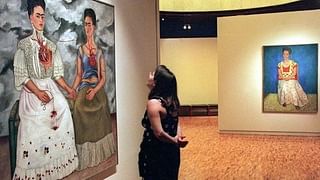 A visitor at the Modern Art Museum of Mexico City looks at a double auto-portrait by Mexican artist Frida Kahlo 22 August 1999. AFP PHOTO/Ramon CAVALLO (Photo by RAMON CAVALLO / AFP)