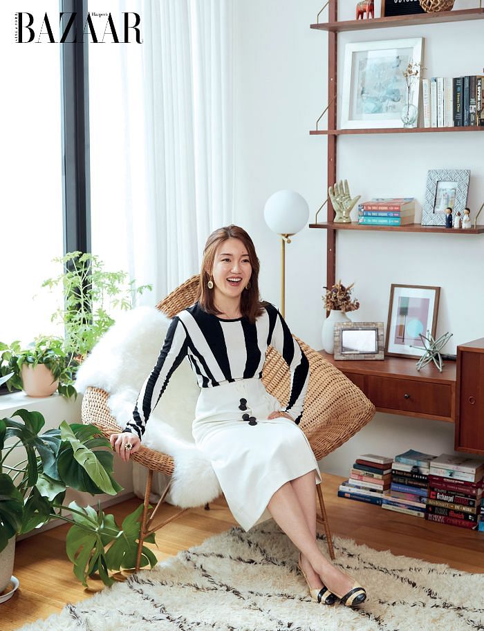 Shen on an inviting rattan chair, wearing a Tory Burch top, and her own Tibi skirt, vintage jewellery and Chanel heels.